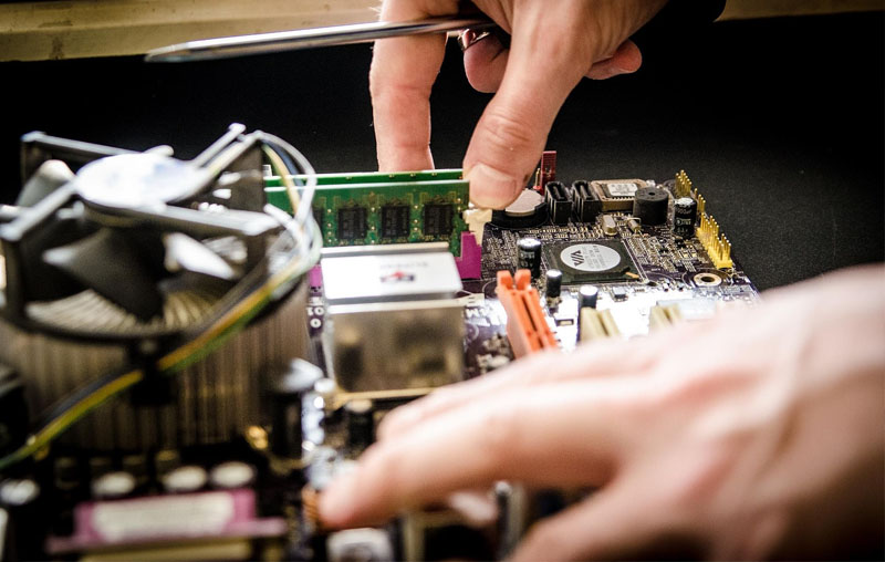 Tecnico Morgimpianti al lavoro su componenti elettronici di precisione